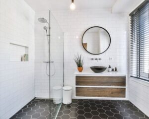 A City bathroom with a sink, mirror, and shower undergoing remodels.