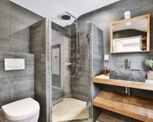 A city bathroom with a toilet, sink, and shower that underwent a remodel.