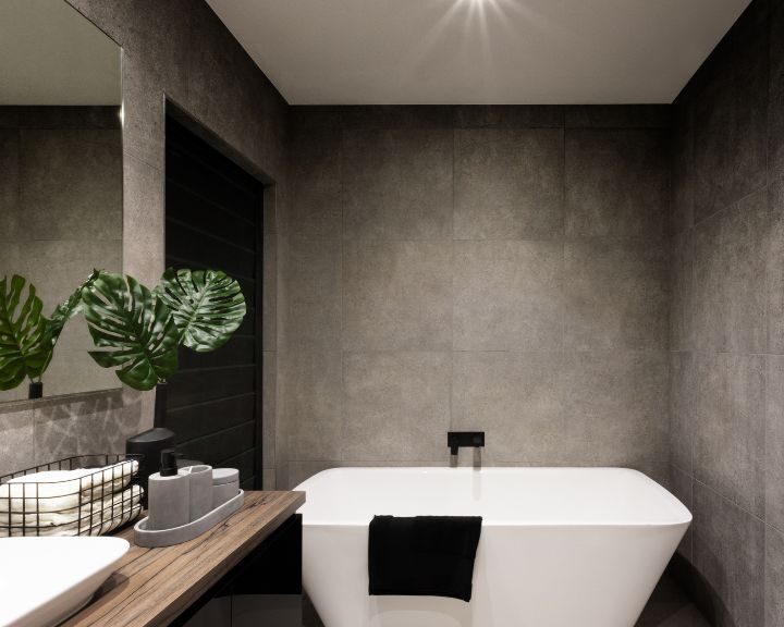 A white bathtub in a bathroom with a mirror above.