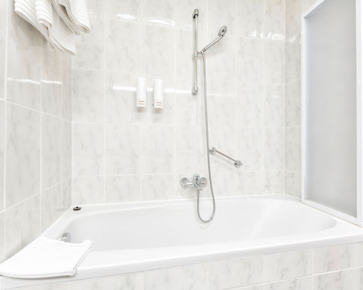 A remodeled city bathroom with a bathtub and a towel rack.